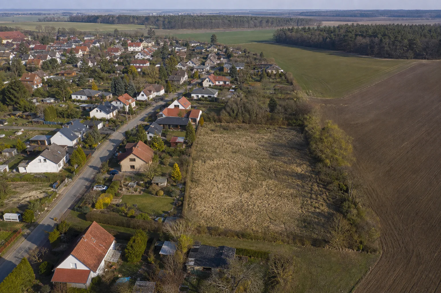 Illustrative Luftaufnahme eines fiktiven Brandenburger Siedlungsrands mit angrenzender Freifläche